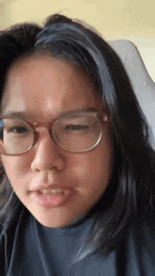 a close up of a woman wearing glasses and a black shirt