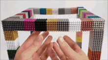 a person is playing with a cube made of magnets