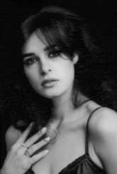 a black and white photo of a woman with her hand on her neck