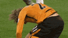 a soccer player wearing a number 7 jersey is kneeling down on the field