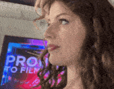 a close up of a woman 's face in front of a sign that says pro to film
