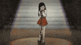 a girl in a red dress is standing in front of a microphone on a stage .