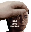 a hand is touching a man 's face with the words sad gay noises written on it .