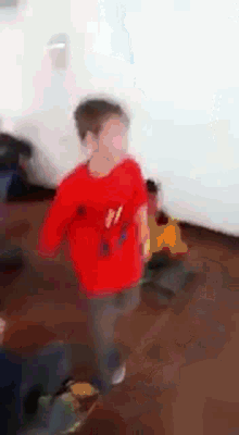 a young boy in a red shirt with the number 11 on it