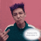 a man with purple hair is giving the middle finger and has a message that says thanos only loves ame