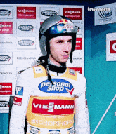 a man wearing a helmet with red bull on it