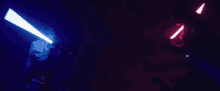 two lightsabers are being used in a dark room