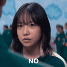 a girl in a green shirt with the word no written on her face