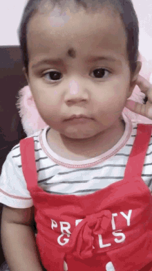 a little girl wearing a red pretty girls outfit