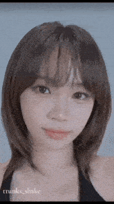 a close up of a woman 's face with a black top on