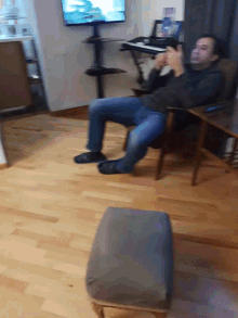 a man is sitting on a chair in a living room