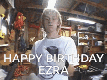 a young man in a garage with the words happy birthday ezra behind him