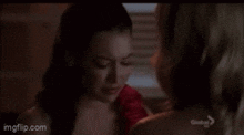two women are hugging each other and one is crying while the other is holding a rose .