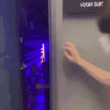 a person is opening a door that has a sign that says hyun suk on it