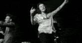 a black and white photo of a woman in a satin shirt