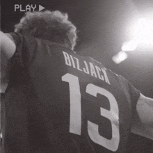 a black and white photo of a man wearing a bizjack 13 jersey