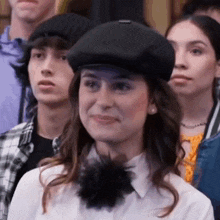 a woman wearing a hat and a flower on her neck is standing in a crowd of people .
