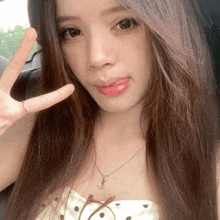 a woman sticking her tongue out while wearing a polka dot top