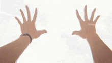 a blurred image of a person 's hands reaching out towards the sky