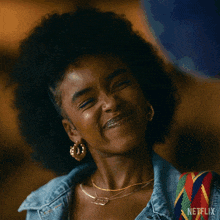 a woman is smiling and wearing a netflix logo