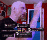 a bald man is standing in front of a red wall with a bunch of messages including one that says thats aura on it
