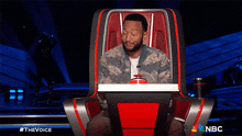 a man sits in a chair with a nbc logo on the bottom