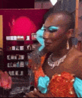 a woman with a shaved head is wearing blue eye shadow