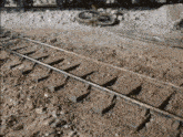 a close up of a train track with a broken wheel in the background