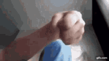 a close up of a person 's fist with a blue cloth on it .