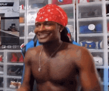 a shirtless man wearing a red bandana on his head is smiling