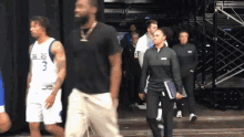 a man in a dallas jersey walks with a woman holding a clipboard