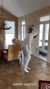 a person in a bunny costume is dancing in a living room with the caption happy easter