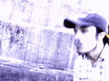 a blurry picture of a man wearing a hat and a plaid shirt