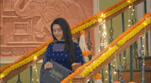 a woman is standing on a set of stairs decorated with yellow and orange flowers .