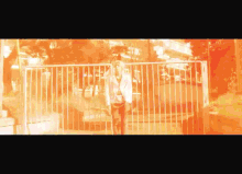 a woman is standing in front of a metal fence