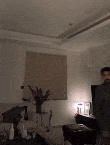 a man is standing in a living room with a couch and television