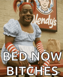 a wendy 's sign is behind a woman in a wendy 's outfit