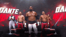 a group of wrestlers are standing on a stage in front of a sign that says dante