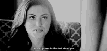 a black and white photo of a woman sitting on a couch with a quote on her face .