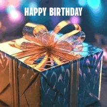 a blue gift box with a gold bow and the words happy birthday on the bottom