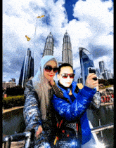 a man and a woman are taking a selfie in front of the twin towers