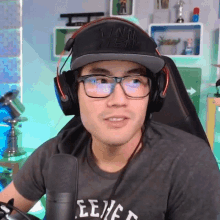 a man wearing glasses and headphones is sitting in front of a mic