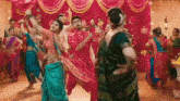 a group of people are dancing in front of a pink curtain in a room .