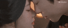 a man and a woman are kissing each other in a close up of their faces .
