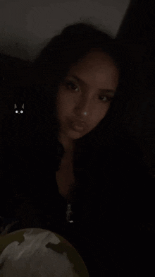 a woman is standing in the dark with a plate of food in her hand .