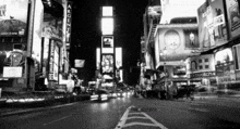 a black and white photo of a city street at night with a sign that says argenti on it