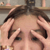 a close up of a woman 's forehead with a picture of a woman in the background
