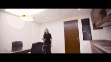 a woman is standing in a room in front of a wooden door