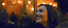 a woman is smiling and looking up at a man in a dark room .