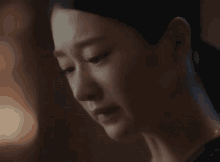a close up of a woman 's face with a tear running down her cheek .